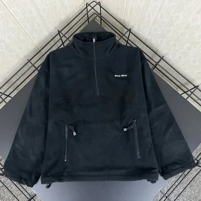 Black half-zip fleece jacket on a plain ground