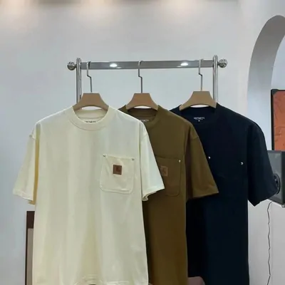 Cream, brown and navy pocket T-shirts on hangers