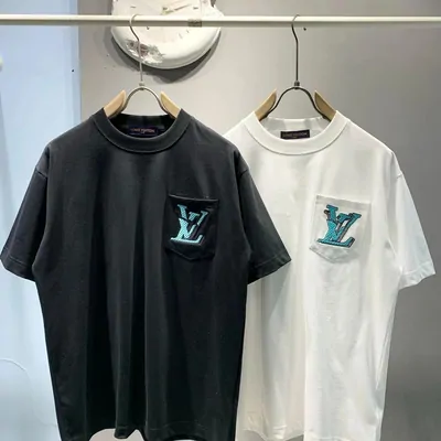 Black and white tees with a contrast chest pocket, hung on a rail